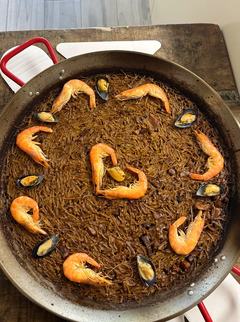 Fideuá el Navarrico en paellera, con gambas y mejillones alrededor