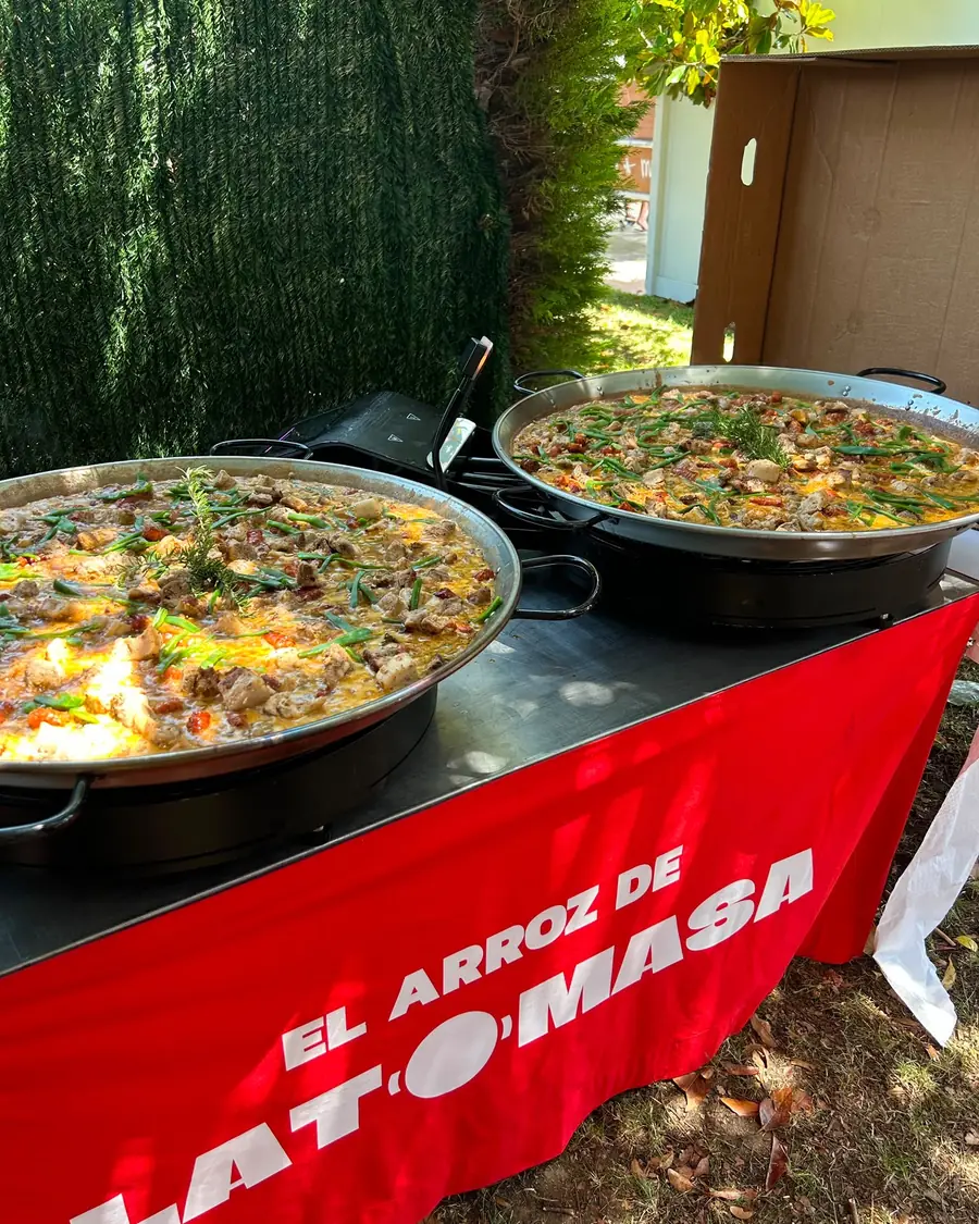 Dos paellas terminadas sobre la mesa de servicio, listas para servir a los invitados
